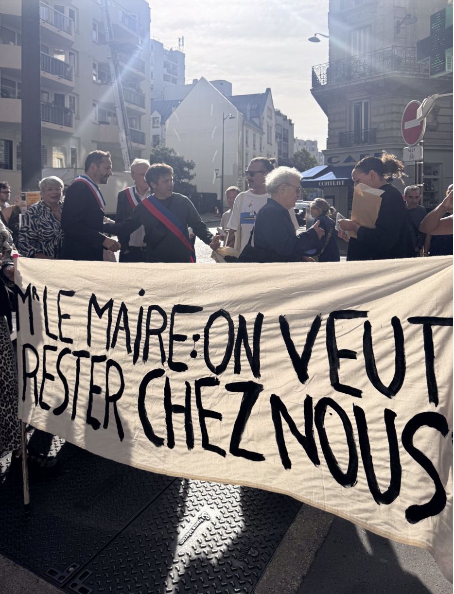Les élus échangent avec les locataires derrière la banderole « Monsieur le Maire, on veut rester chez nous »